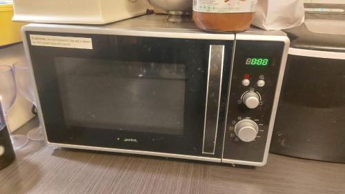 a microwave oven sitting on top of a kitchen counter at Room close to city centre and beach in Oslo