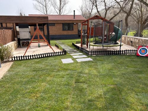 a yard with a playground with a swing at Casa rural Los Pilares de la Sierra in Arahuetes