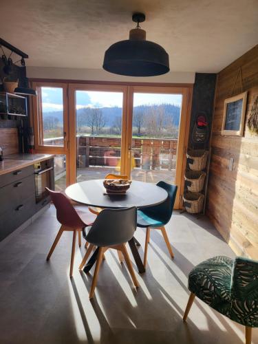 eine Küche mit einem Tisch und Stühlen sowie einem Fenster in der Unterkunft Le cocon du rondeau(gîte cosy) in Labergement-Sainte-Marie