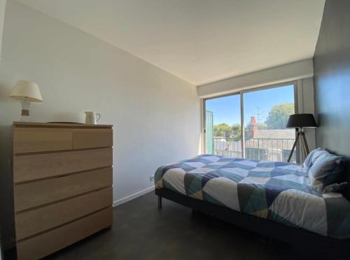 une chambre avec un lit, une commode et une fenêtre dans l'établissement Vue sur les toits de Tours, à Tours