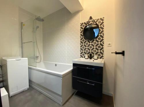 une salle de bain avec une baignoire et un lavabo et une baignoire dans l'établissement Vue sur les toits de Tours, à Tours