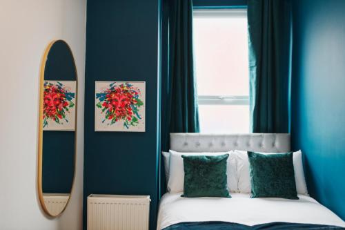 a bedroom with blue walls and a bed with a mirror at Captivating 2-Bed Apartment in Liverpool in Liverpool