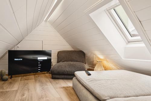 a attic bedroom with a chair and a tv at 2024 Renovated Luxury Penthouse! Up To 9 Guests! in Bergen