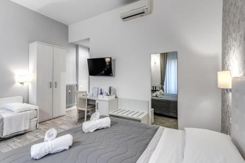 ローマにあるGardenia Suiteの大きなベッドとデスクが備わるホテルルームです。