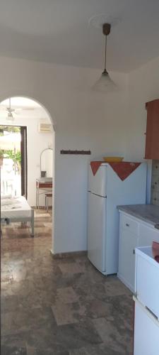 a kitchen with a refrigerator and a table in a room at Avouris Studios in Kypseli