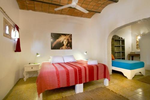 a bedroom with a bed and a table and a ceiling fan at Petit Hotel Hafa in Sayulita