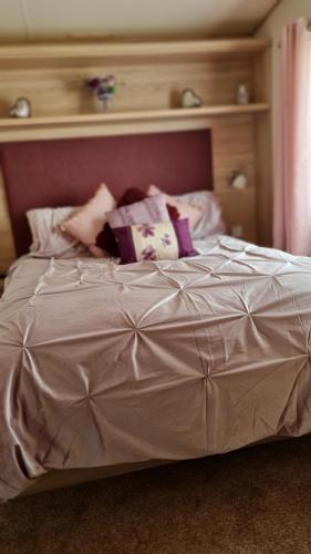 a large white bed with a pink headboard and pillows at Stunning 2 Bed Static Caravan at Hoburne Devon Bay in Goodrington