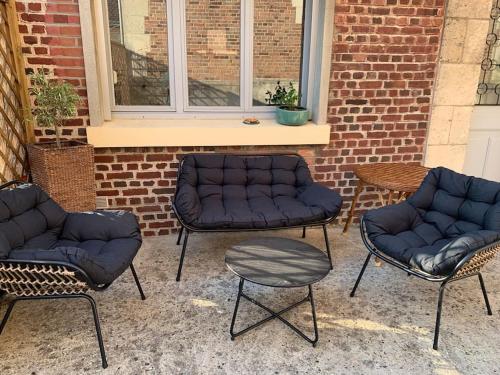 a group of four chairs and a table and a couch at La Soissonnaise, maison de ville à Soissons in Soissons