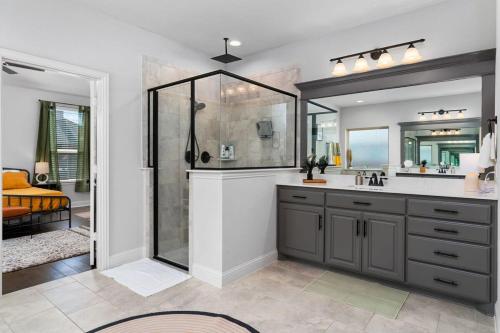 W łazience znajduje się prysznic, umywalka i lustro. w obiekcie The Noble House Near Magnolia & Baylor W Pool w mieście Hewitt