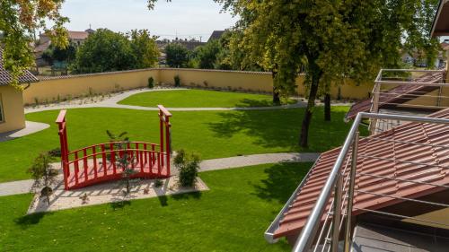 una vista sul parco con un cancello rosso di EPRESPARK Panzió a Vecsés