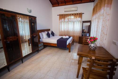 a bedroom with a bed and a table in a room at Villa Sun Grace in Galle