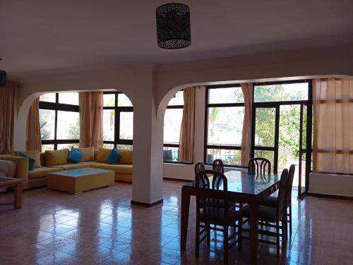 Villa El Ghriss في بين الويدان: غرفة معيشة مع طاولة وكراسي وأريكة