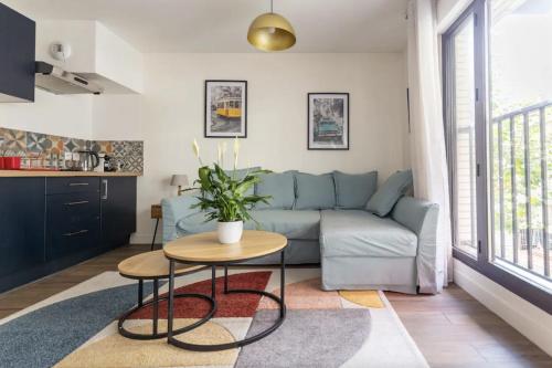 a living room with a couch and a table at L'Escapade Paris in Le Kremlin-Bicêtre