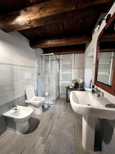 a bathroom with two sinks and a toilet and a mirror at La Grangia in Giaveno