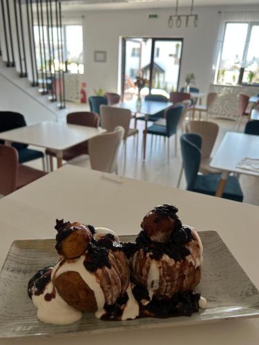 a dessert on a plate on a table at Pensiunea La Cazemata Bucov in Satu Bucovei