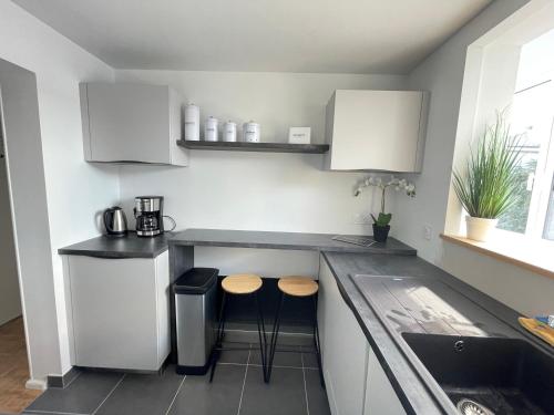 une cuisine avec deux tabourets et un comptoir dans l'établissement Grand appartement cosy 4ch, à Cholet