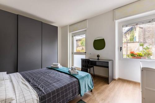 1 dormitorio con cama, escritorio y ventana en Valeria Apartment en Bardolino