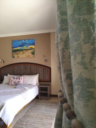 a bedroom with a bed and a curtain at Goba Lodge in Gobabis