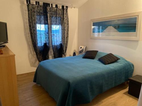 une chambre avec un lit bleu et une fenêtre dans l'établissement La Maison du Bonheur, à Octon