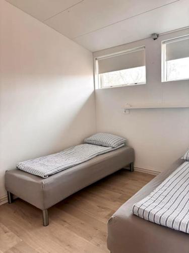 two beds in a room with two windows at Selfoss Center apartment in Selfoss