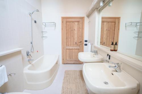 a white bathroom with two sinks and a mirror at FARM HOUSE in Roncade