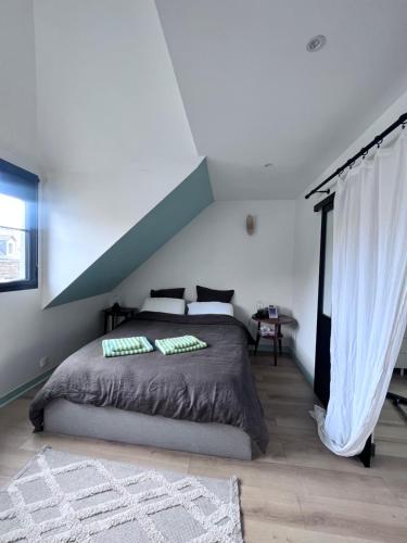 ein Schlafzimmer mit einem großen Bett mit einem Dach in der Unterkunft Charmante chambre avec sa salle de bain, vue mer. in Le Conquet