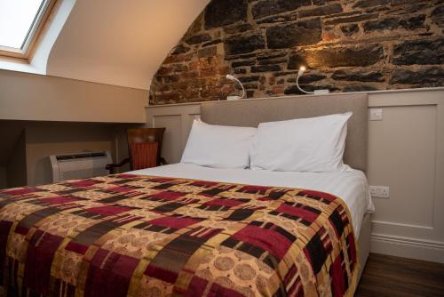 1 dormitorio con cama y pared de ladrillo en Donegal House, en Donegal
