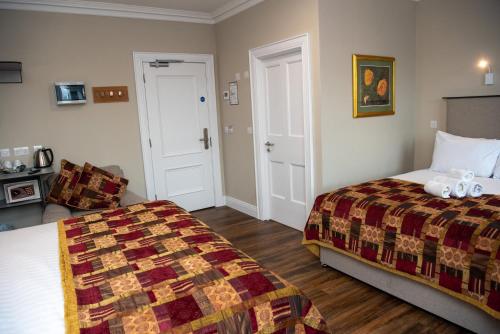 a hotel room with two beds and a chair at Donegal House in Donegal
