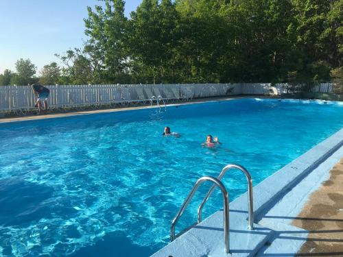 Dos personas nadando en una piscina azul en The Lodge at Poland Spring Resort, en Poland Spring