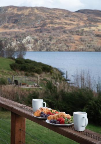 a tray of bread and fruit on a table with two cups at Shoreland Lodges - Holly Lodge in Fort Augustus