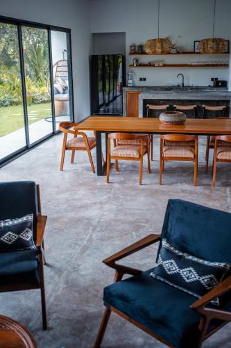 a living room with a wooden table and chairs at Hatiku Di Bali - Ubud in Tegalalang