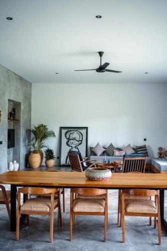 a living room with a wooden table and chairs at Hatiku Di Bali - Ubud in Tegalalang