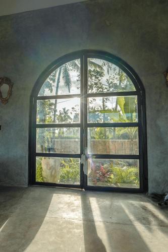 an arched window in a room with an open door at Hatiku Di Bali - Ubud in Tegalalang