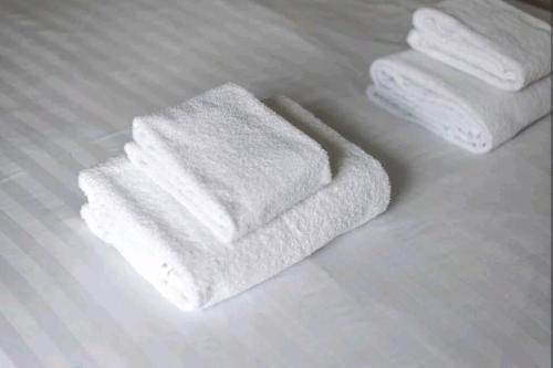uma pilha de toalhas sentadas numa cama em 2BD House Canal View and Garden em Londres