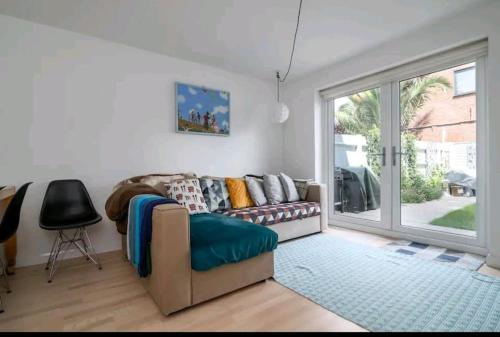 uma sala de estar com um sofá e uma porta de vidro deslizante em 2BD House Canal View and Garden em Londres