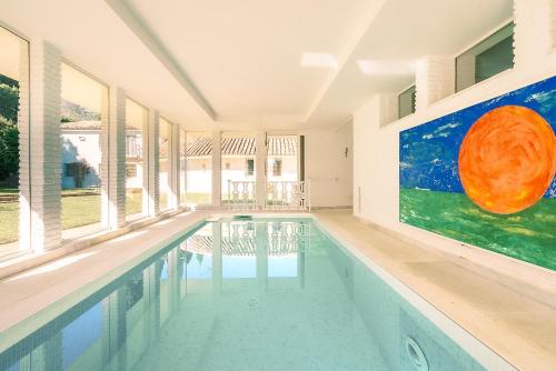 a swimming pool in a house with a painting on the wall at 7,000 sqm Luxurious Villa with Panoramic Sea Views Multiple Gardens & Two Pools in Benalmádena