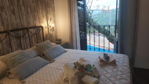 a bedroom with a bed with towels and a balcony at Cortijo Molino los Justos in Fuentes de Cesna