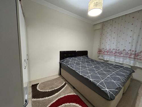 a bedroom with a bed and a window and a rug at Troya Suit in Canakkale