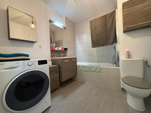 une salle de bain avec machine à laver et toilettes dans l'établissement Charmant T2 avec piscine, à La Londe-les-Maures