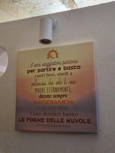 a sign attached to a wall with a light at La Grottina in Bisceglie