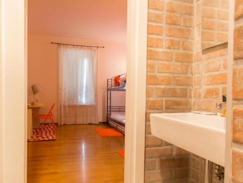 サン・ピエーロ・ア・シエーヴェにあるLa Stazione Per Dormire Guest Houseの白い洗面台とレンガの壁が備わるバスルーム
