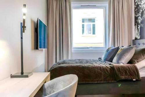 um quarto com uma cama e uma janela em **ROYAL SUITE ** MODERN ** FAST - WIFI ** SMART TV ** em Oslo