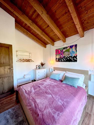 - une chambre avec un grand lit et une couverture violette dans l'établissement Vista suggestiva sulle montagne!, à Ovindoli