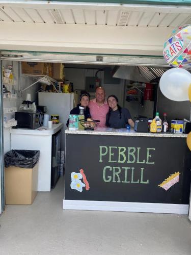 a group of people standing at a peelle grill at Sand Pebble Motor Lodge in Point Pleasant Beach