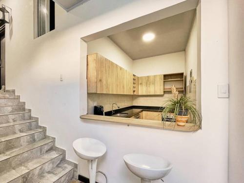 eine Küche mit einem Waschbecken, einer Theke und einer Treppe in der Unterkunft M12. Casa Moai Casa grande ubicado a 5 min de San Antonio. in Cali