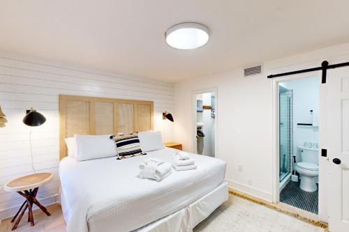 Habitación blanca con cama y baño. en 3542 Seascape Villa, en Kiawah Island