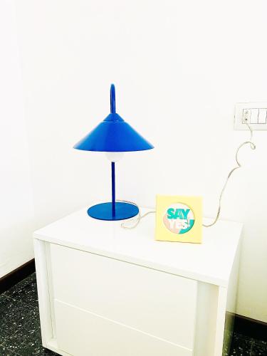 a blue lamp on top of a white dresser at The Luxe by Maiden Art in Arona