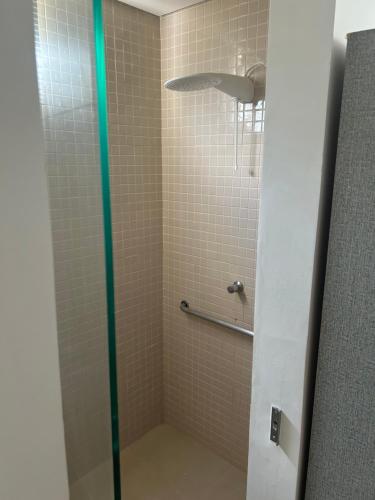 a shower with a glass door in a bathroom at Apartamento Chique frente ao mar in Flecheiras