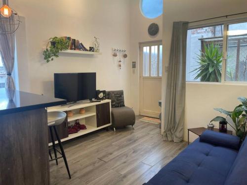 a living room with a blue couch and a tv at Loft hermoso con bella vista de la ciudad in San Luis Potosí