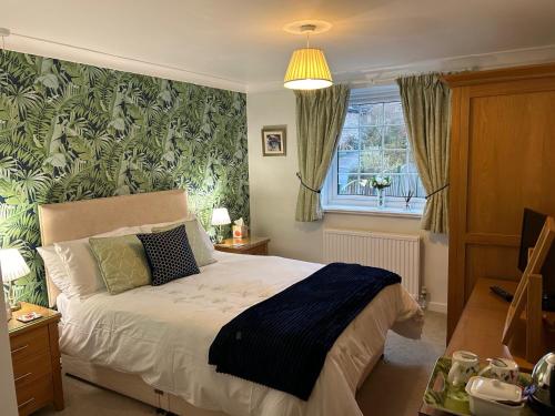 a bedroom with a bed with a green wall at THE FIRS B&B &TEA ROOM in Summer Bridge